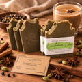 Three handmade olive oil soaps by Espuma Apothecary are displayed on a rustic wooden table with ingredients like star anise, cinnamon, and cardamom pods. A glass mug of chai with a star anise sits in the background. It also has a kraft card with a phrase in it.