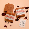 Hibiscus and Honey handmade soap by Espuma Apothecary displayed with dried hibiscus petals on a soft peach background.