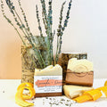 Two bars of Espuma Apothecary handmade tallow soap in lavender and orange scent, displayed with dried lavender and orange peels on a neutral background.