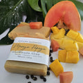 Mango Papaya handmade soap by Espuma Apothecary made with mango, papaya, and goat milk, displayed with fresh mango and papaya pieces on a white surface.