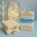 Re-Generate handmade soap by Espuma Apothecary displayed in cream-colored bars, including a labeled bar, on a soft blue background.