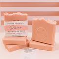 Handmade Serene soap bars by Espuma Apothecary in soft blush pink, stacked and displayed with product label showing coconut milk and calamine clay.